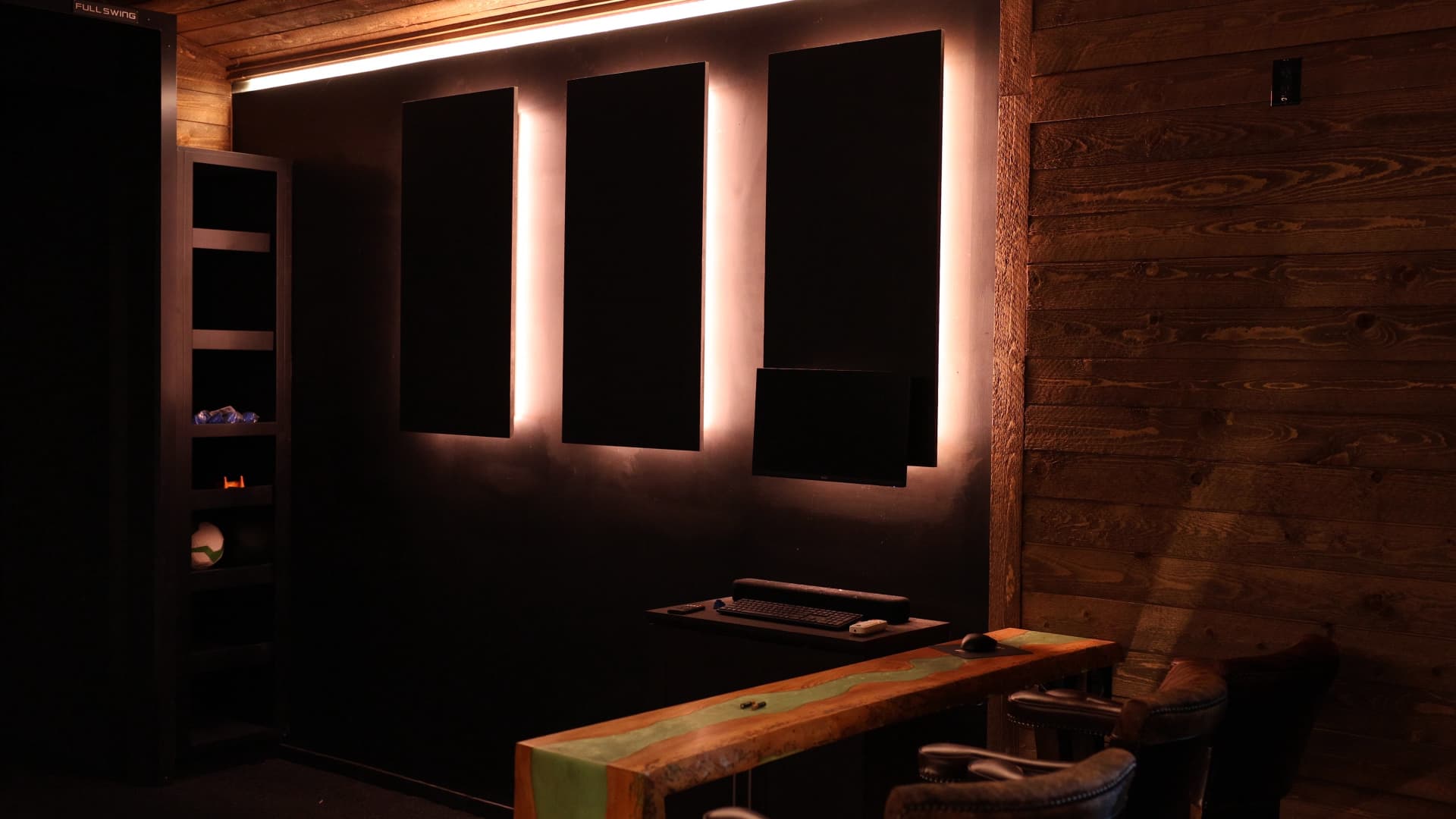Finished lounge with black wall panels backlit in warm LED light, wired by iPowerDenver