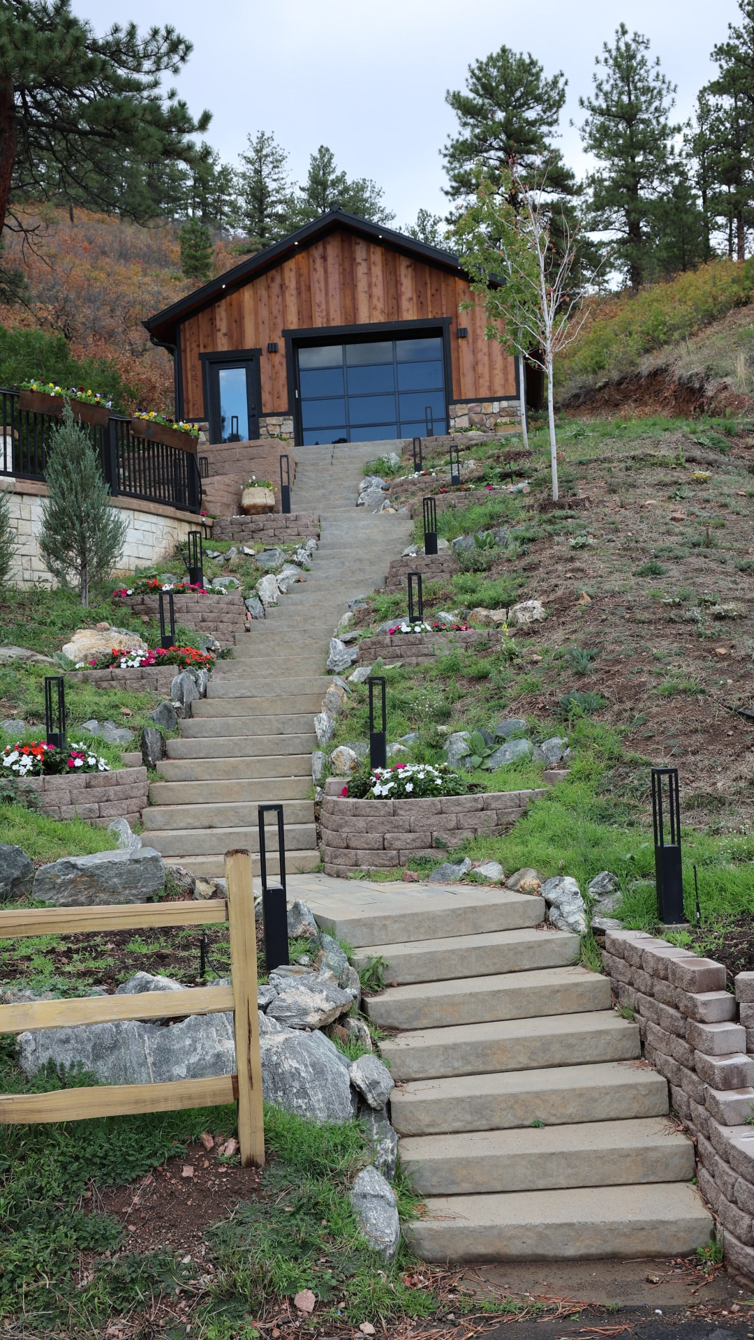 Hillside commercial property with tiered stone steps, planter walls and black path lights wired by iPowerDenver